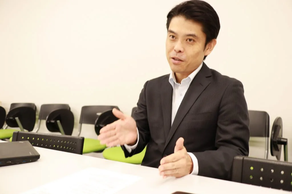 会議室で身振りを交えて研修について語る様子